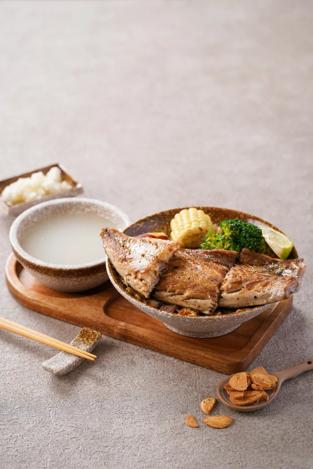 A pan-fried fish fillet over egg fried rice, with chicken soup and pickled radish