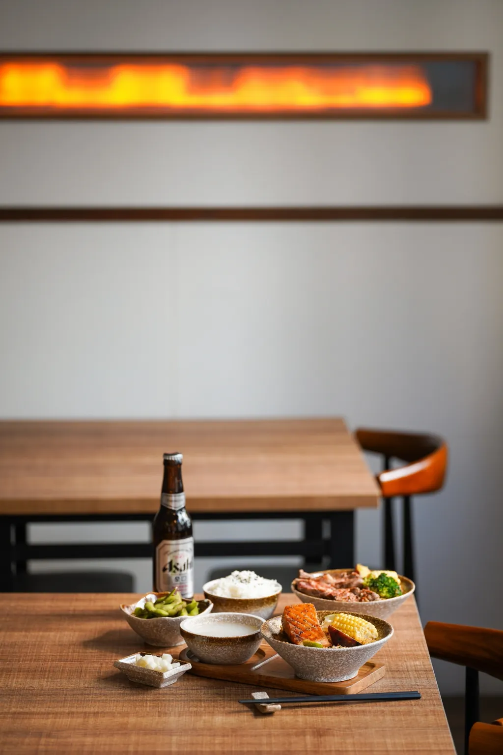 A fiery light strip on the wall above a table set with food