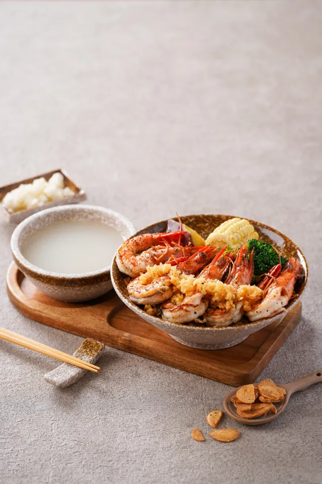 去殼的大草蝦蓋在蛋炒飯上，配玉米與花椰菜