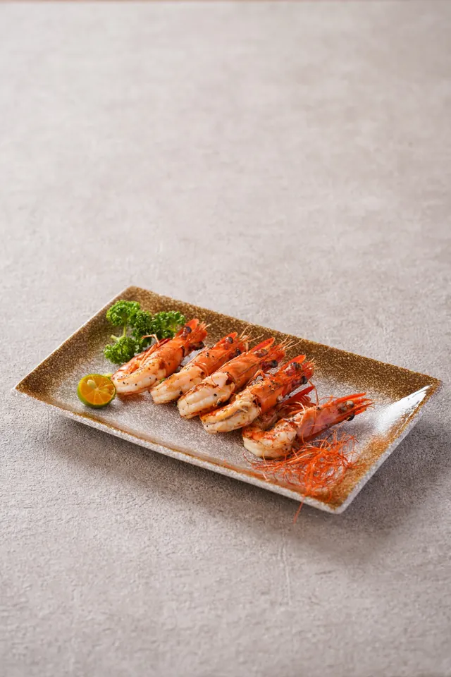 Five seared tiger prawns on a long plate